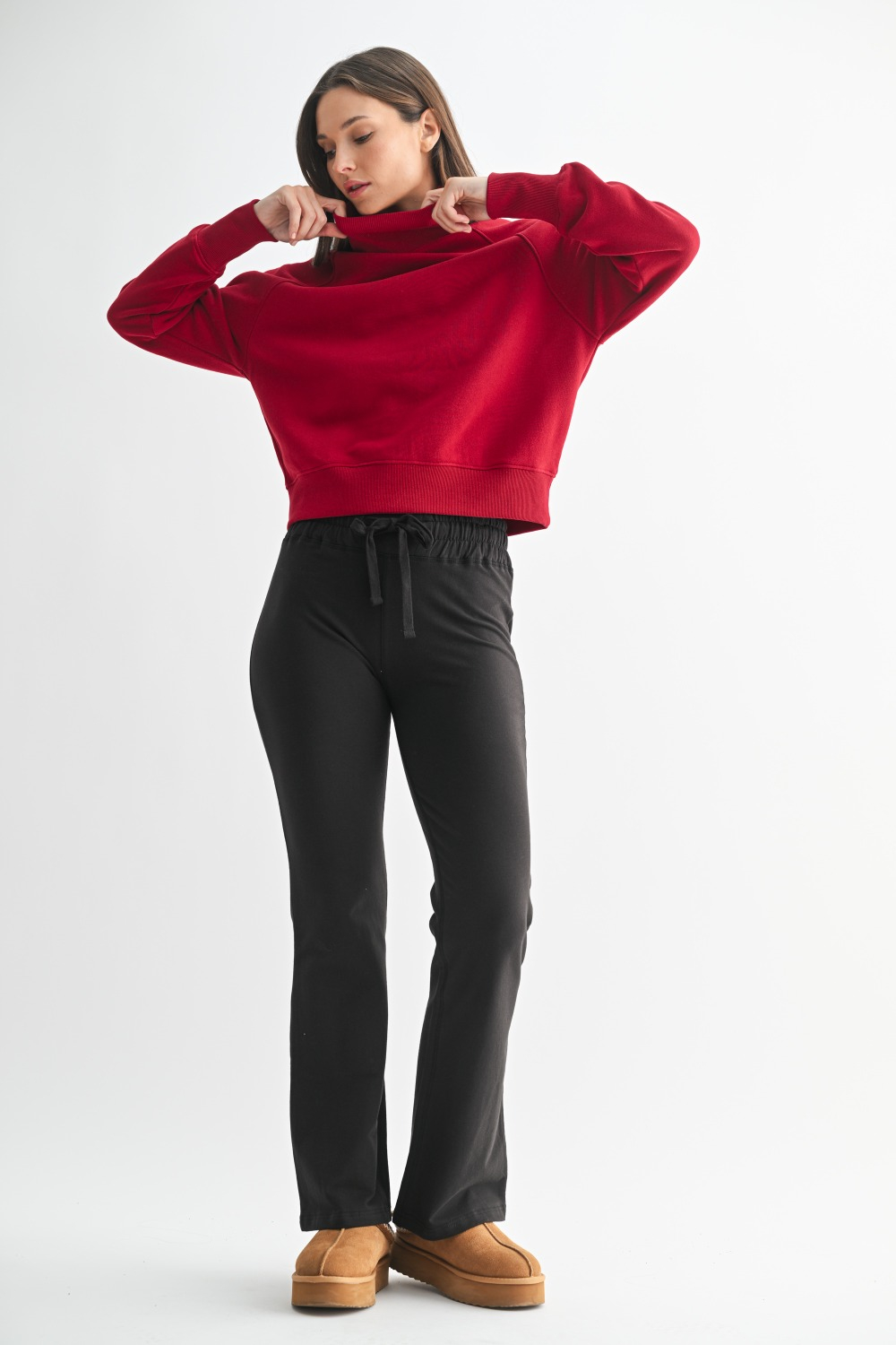 Model wearing a garnet red cotton raglan sleeve turtleneck sweater with ribbed trim and relaxed fit, styled for fall layering.